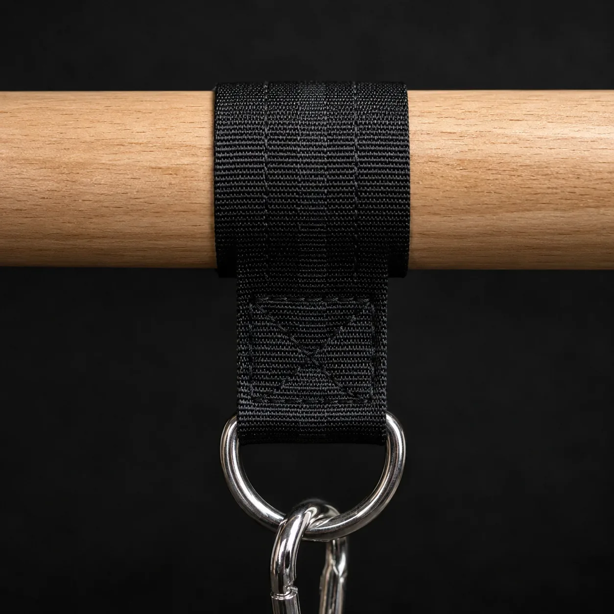 Close-up of the cross-stitched nylon strap and steel D-ring wrapped around the wooden handle