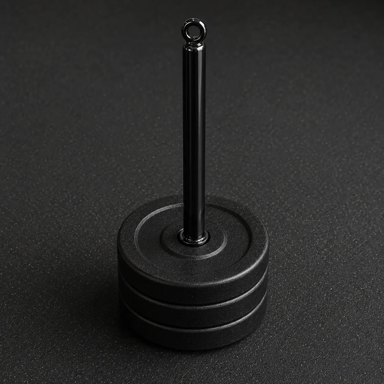 Loading pin loaded with three cast-iron weight plates, its top ring left open, standing on a rubber gym floor